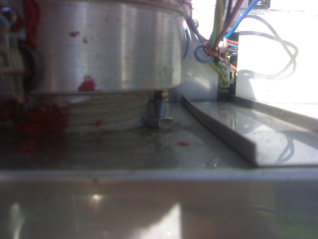 Tässä näkyy vasemman keittolevyn kiinnityspultti, joka siis on lyötävä vinoksi, jotta polttimen saa osumaan keittolevyn pohjassa